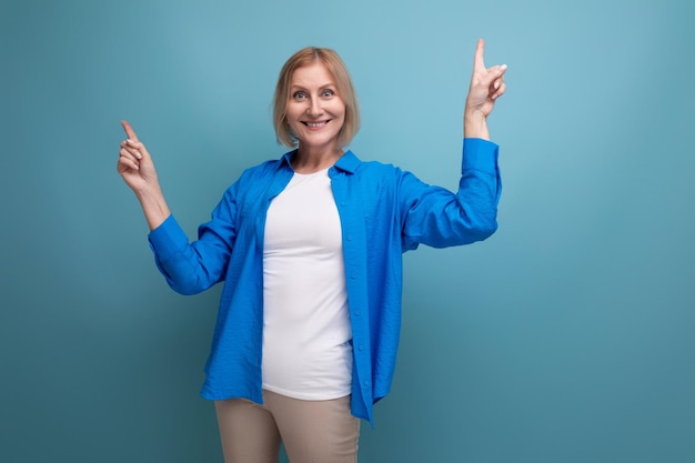 Mulher de meia-idade moderna informal em uma linda camisa mostra emoções por dentro