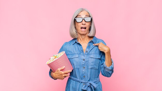 Foto mulher de meia-idade parecendo chocada e surpresa com a boca bem aberta, apontando para o conceito do auto-filme