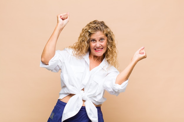 Mulher de meia idade parecendo extremamente feliz e surpresa