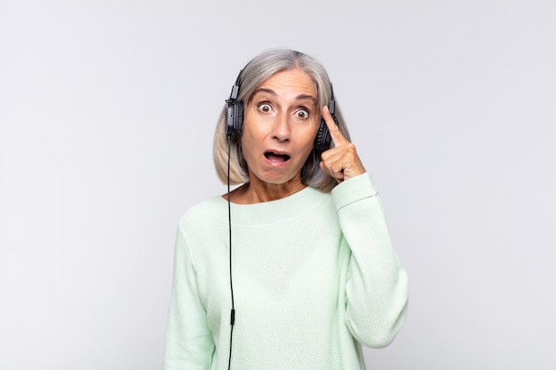 Mulher de meia-idade parecendo surpresa, boquiaberta, chocada, percebendo um novo pensamento, ideia ou conceito. conceito de musica