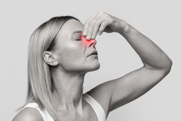 Foto mulher de meia idade que sofre de sangramento nasal closeup