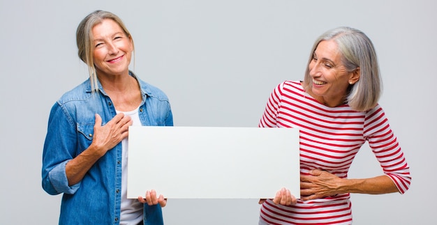 Mulher de meia-idade rindo alto de uma piada hilária, sentindo-se feliz e alegre, se divertindo