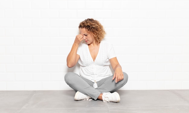 Foto mulher de meia-idade se sentindo estressada, infeliz e frustrada, tocando a testa e sofrendo de enxaqueca ou forte dor de cabeça