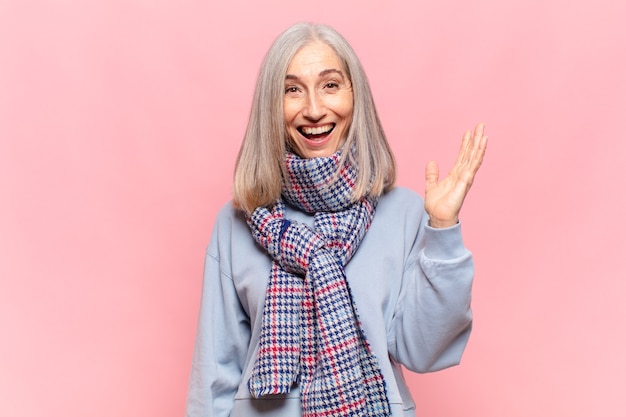 Mulher de meia idade se sentindo feliz, surpresa e alegre, sorrindo com atitude positiva, percebendo uma solução ou ideia