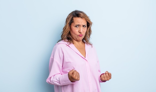 Mulher de meia-idade se sentindo irritada, irritada, rebelde e agressiva, sacudindo o dedo do meio, lutando contra