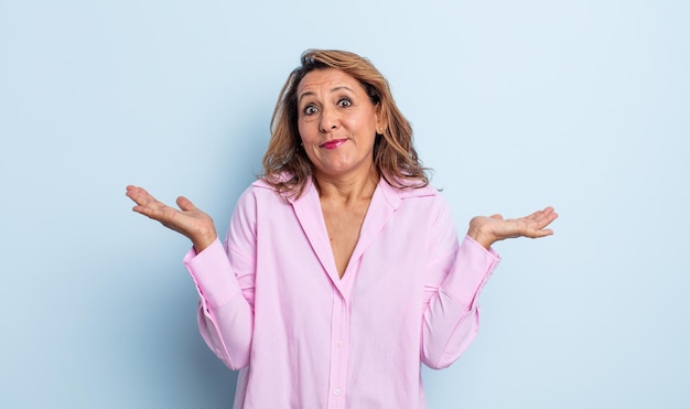 Foto mulher de meia-idade se sentindo perplexa e confusa, duvidando, ponderando ou escolhendo diferentes opções com expressão engraçada