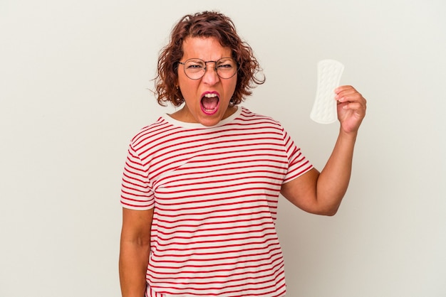 Foto mulher de meia idade segurando uma compressa isolada no fundo branco, gritando com muita raiva e agressividade.