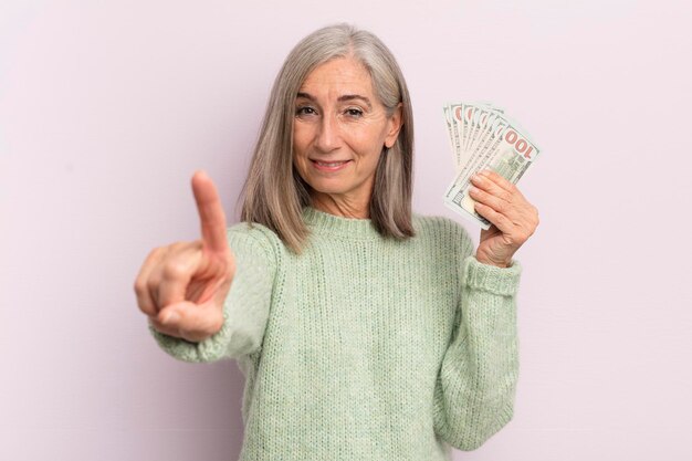 Mulher de meia idade sorrindo e parecendo amigável, mostrando o conceito de notas de dólar número um