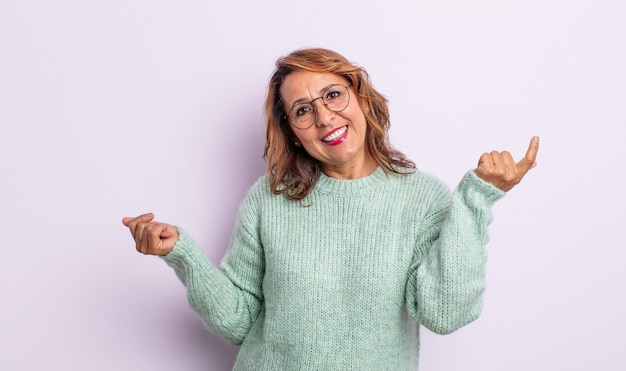 Mulher de meia-idade sorrindo, sentindo-se despreocupada, relaxada e feliz, dançando e ouvindo música, se divertindo em uma festa