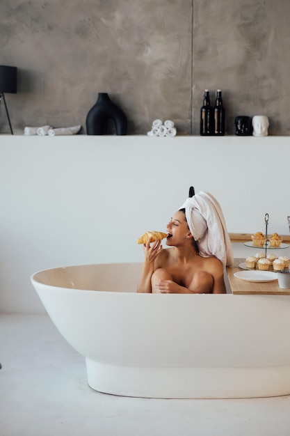 Foto mulher de moda de luxo pela manhã toma café da manhã deitada no banho