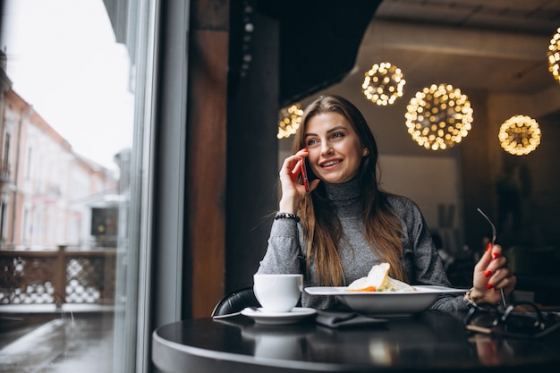 Mulher de negócio falando ao telefone no almoço em um café