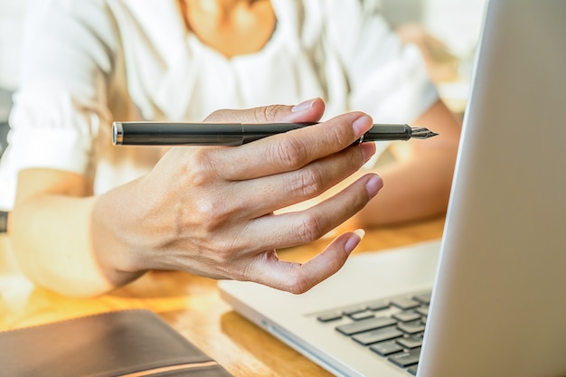 Mulher de negócio que trabalha no escritório com laptop e documentos em sua mesa. Conceito de negócios.