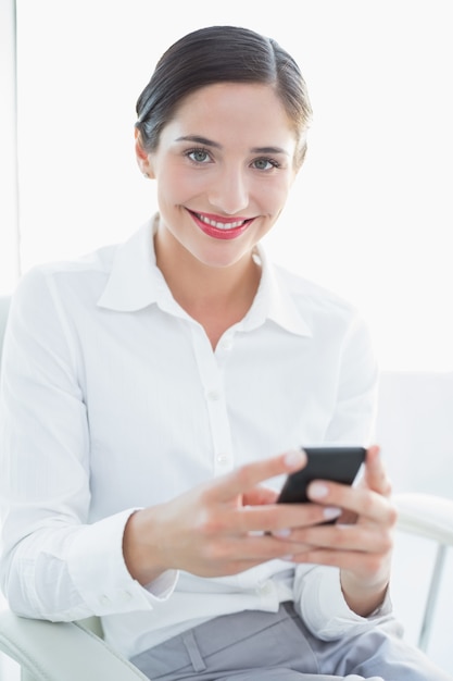 Mulher de negócio sorridente com telefone celular