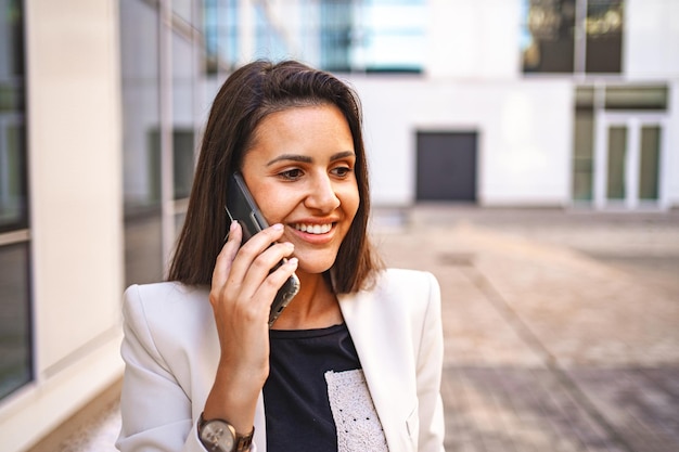 Mulher de negócios a falar ao telefone depois do trabalho.