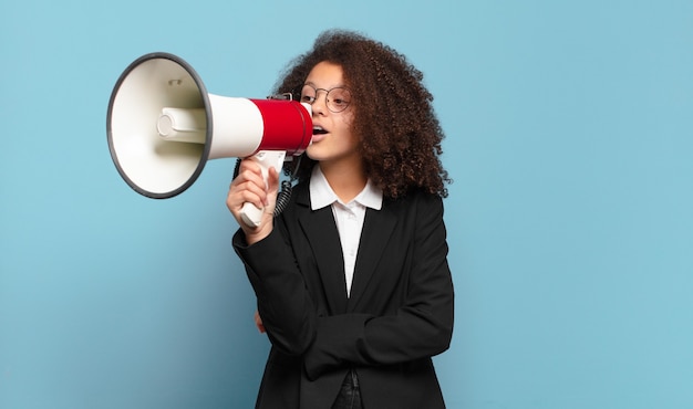 Mulher de negócios adolescente bonita e afro com um megafone