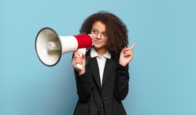 Mulher de negócios adolescente bonita e afro com um megafone