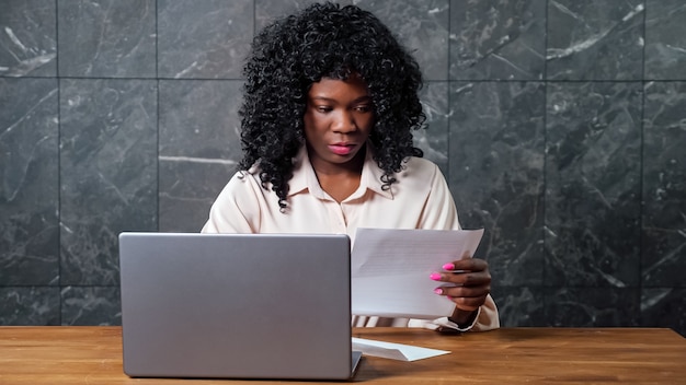 Mulher de negócios afro-americana abre o envelope e insere o código