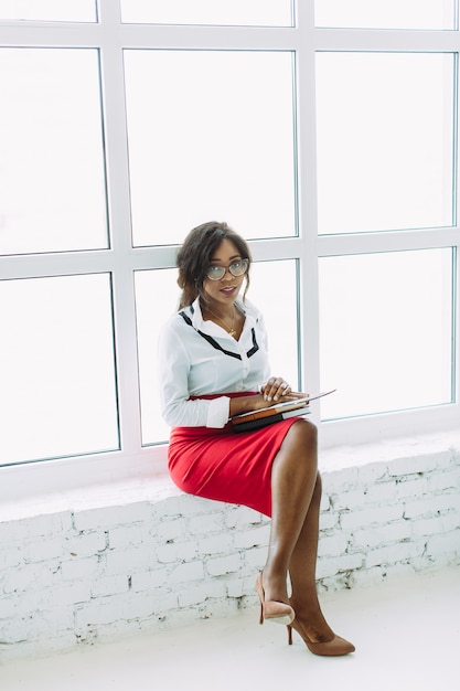 Mulher de negócios afro-americanos sentado perto da janela