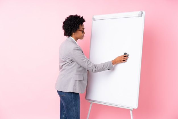 Mulher de negócios afro-americanos sobre parede rosa