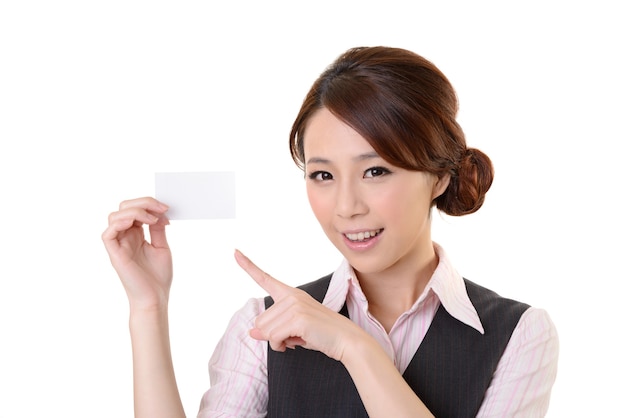 Mulher de negócios alegre segurando um cartão em branco, retrato do close up na parede branca.