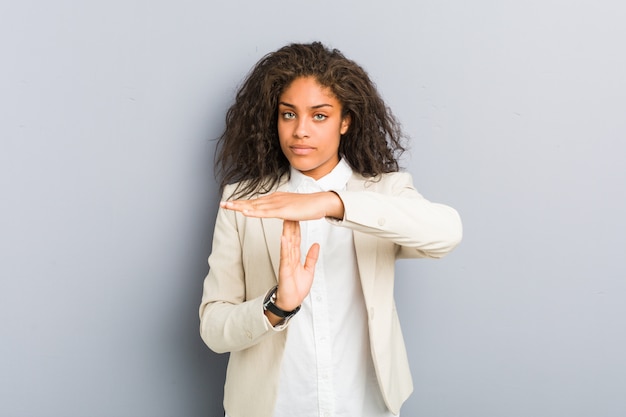 Mulher de negócios americana Africano jovem mostrando um gesto de tempo limite.