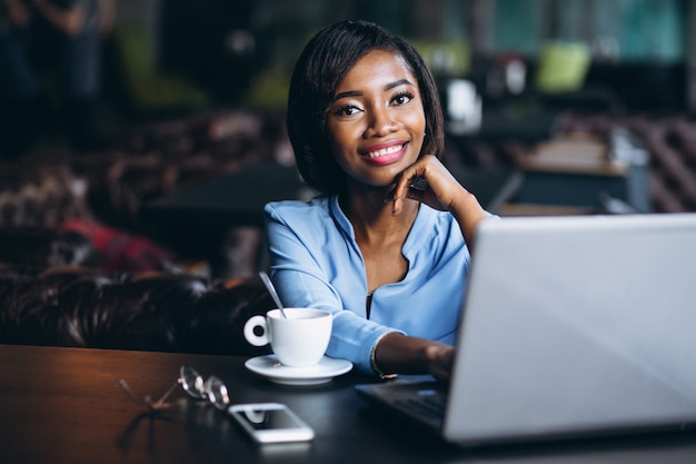 Mulher de negócios americano africano com laptop em um café