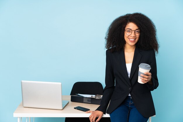 Mulher de negócios americano africano trabalhando em seu local de trabalho rindo