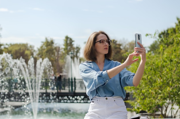 Mulher de negócios andando na rua da cidade, parque, falando em seu telefone, fazendo selfie, funciona. dia ensolarado