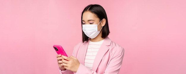 Mulher de negócios asiática em máscara facial médica usando telefone celular vendedora japonesa senhora corporativa em su