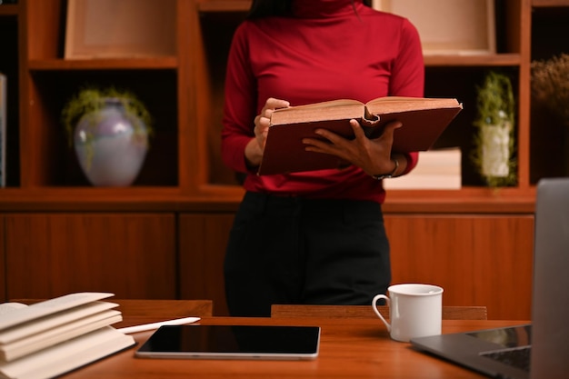 Mulher de negócios asiática em seu escritório procurando informações em seu livro de negócios imagem recortada