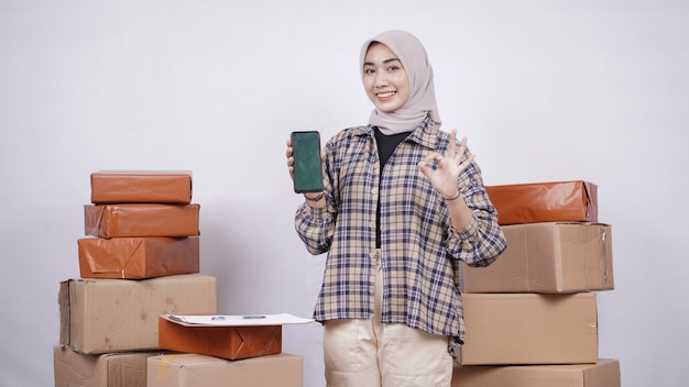 Mulher de negócios asiática mostrando a tela do smartphone gesticulando bem, isolado no fundo branco