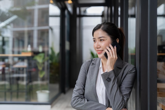 Mulher de negócios asiática sorridente fazendo uma ligação