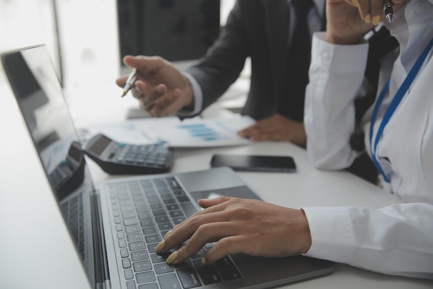 Mulher de negócios asiática usando computador portátil e trabalhando no escritório com documento de calculadora na mesa fazendo planejamento analisando o conceito de análise de finanças de investimento de plano de negócios de relatório financeiro