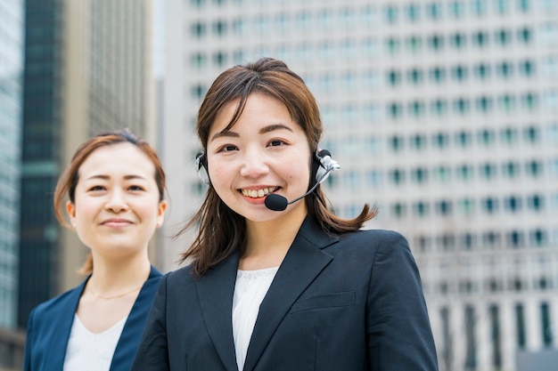 Foto mulher de negócios asiática usando fone de ouvido no distrito comercial