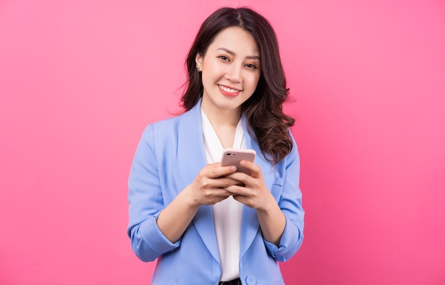 Mulher de negócios asiática usando smartphone rosa