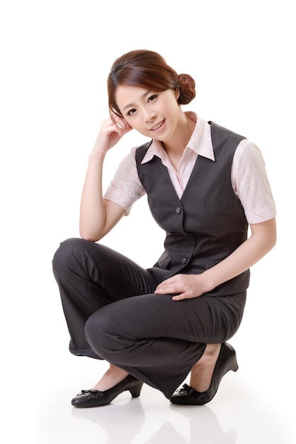 Mulher de negócios asiáticos agachamento, retrato de corpo inteiro isolado na parede branca.