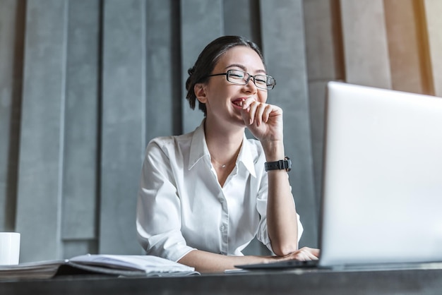 Mulher de negócios asiáticos feliz usando notebook para trabalho