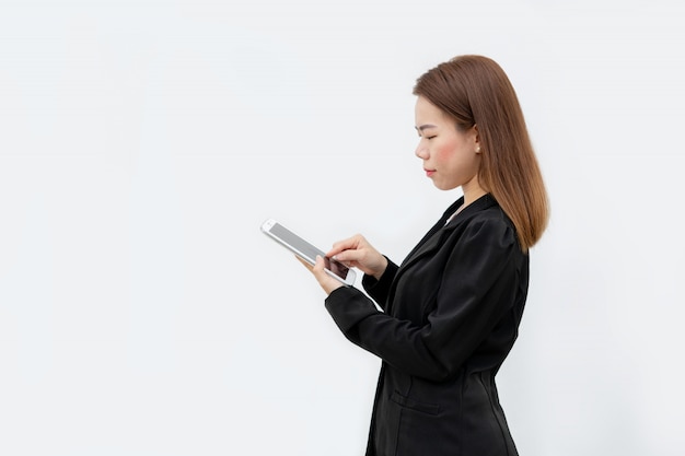 Mulher de negócios asiáticos feliz usando o tablet no terno preto isolado na cor branca