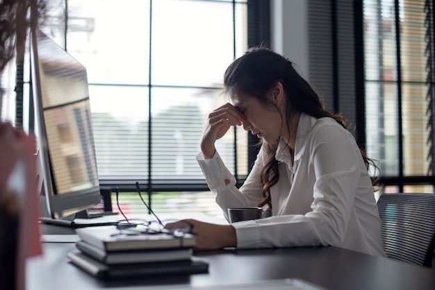 Mulher de negócios asiáticos jovem se sentindo doente e cansada ou exausta do trabalho de escritório.