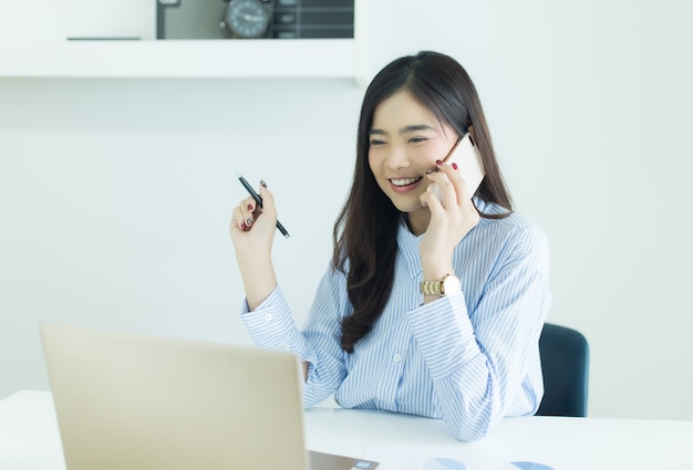 Foto mulher de negócios asiáticos jovens falando no celular