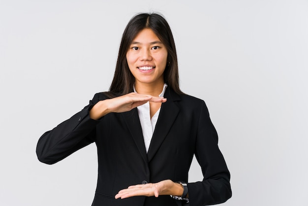 Mulher de negócios asiáticos jovens segurando algo com ambas as mãos