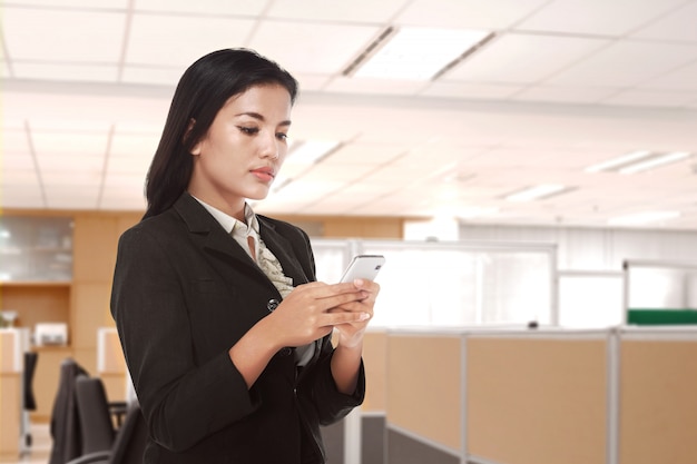 Mulher de negócios asiáticos jovens usando um telefone celular