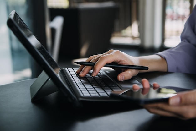 Mulher de negócios asiáticos usando calculadora e laptop para fazer finanças matemáticas em uma mesa de escritório relatório fiscal estatísticas contábeis e conceito de pesquisa analítica