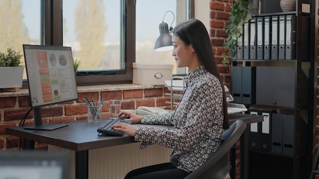 Mulher de negócios asiáticos usando computador para trabalhar no planejamento de projetos, fazendo apresentação financeira para desenvolvimento. Funcionário da empresa usando tecnologia para projetar estratégia de marketing online.