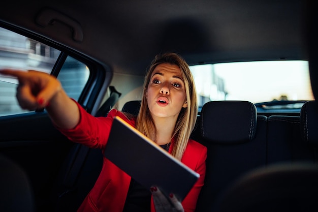 Mulher de negócios atraente, mostrando a direção para seu motorista