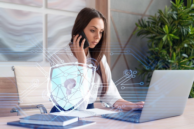 Mulher de negócios atraente na camisa branca tem teleconferência de segurança cibernética na divisão de conformidade para proteger as informações confidenciais dos clientes ícones de bloqueio de holograma de ti sobre o fundo do escritório