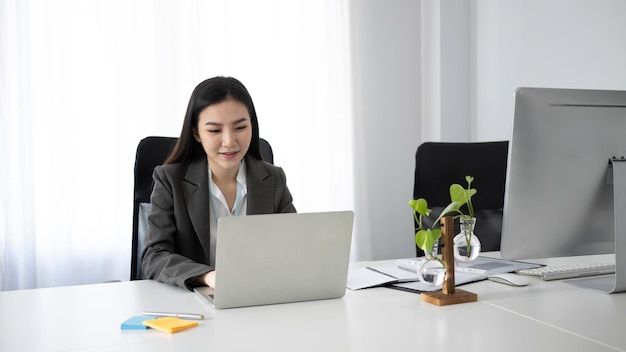 Mulher de negócios atraente trabalhando com dispositivos modernos no escritório.