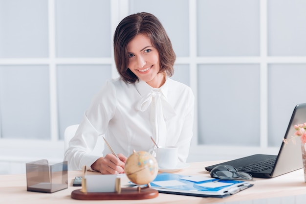 Mulher de negócios atraente trabalhando na mesa do escritório