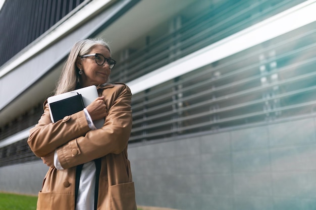 Mulher de negócios bem sucedida idosa no contexto de um prédio de escritórios moderno