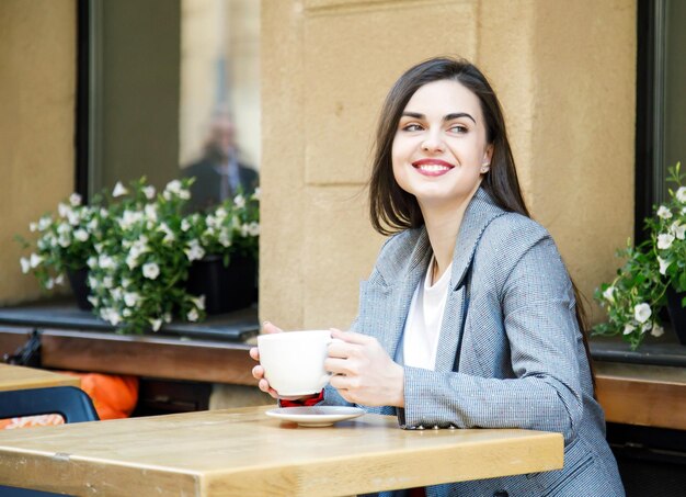 Mulher de negócios bem-sucedida tomando café na rua